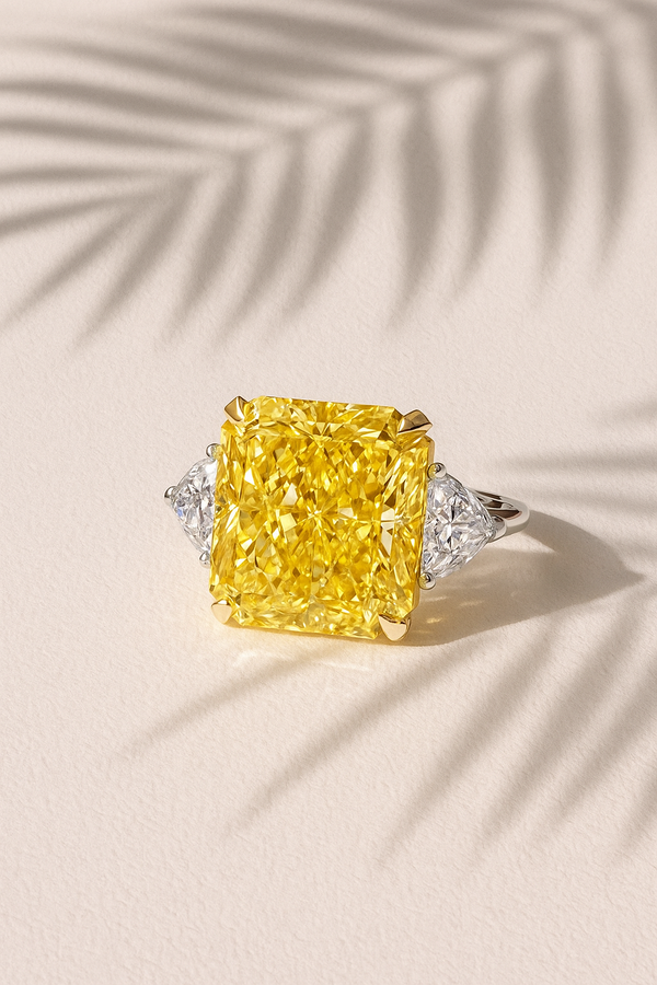 Ring with a large yellow diamond and smaller diamonds on a light background